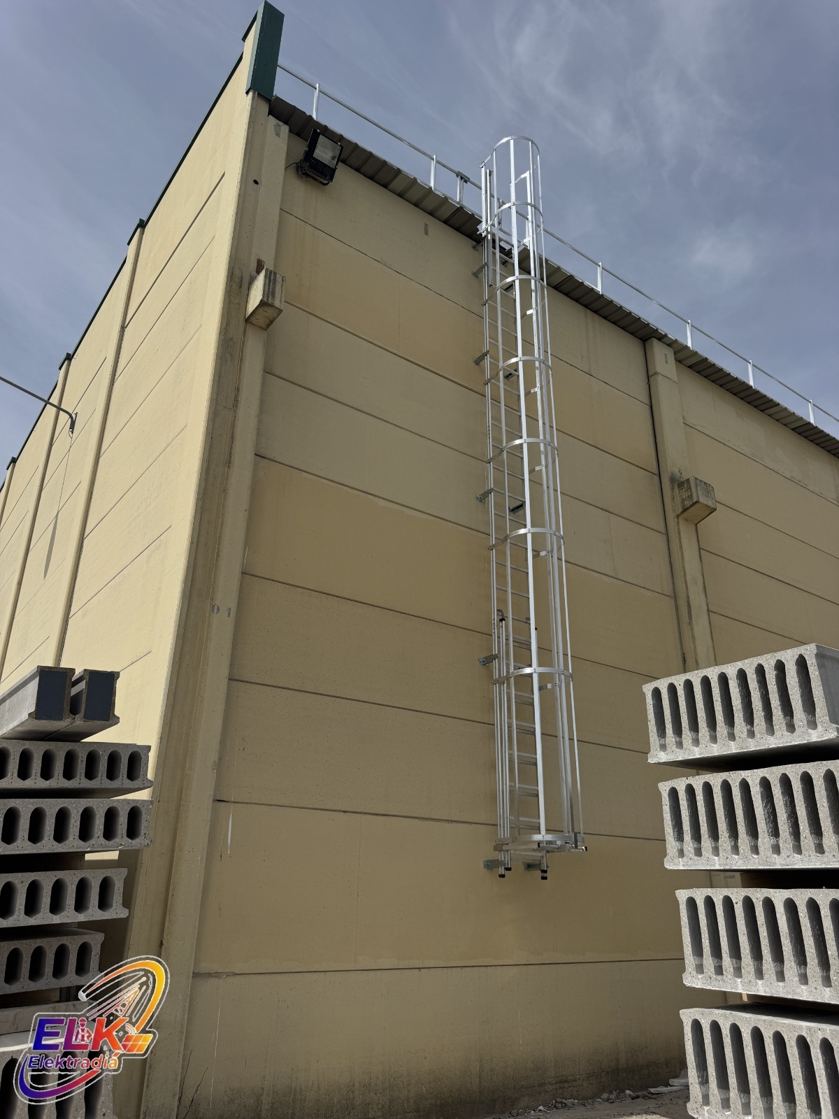 Escalera de acceso seguro a cubierta fijada en fachada industrial